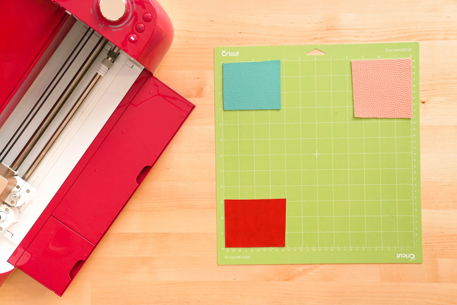 Cricut mat with faux leather squares in three corners.