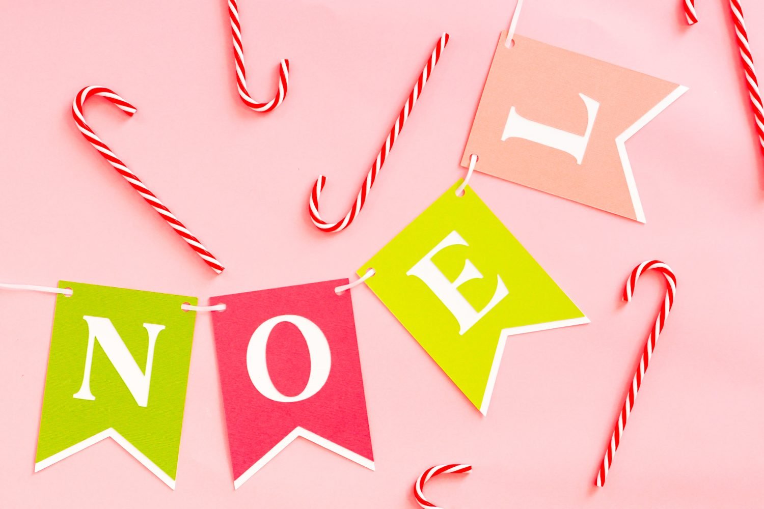 NOEL Banner on pink background with candy canes