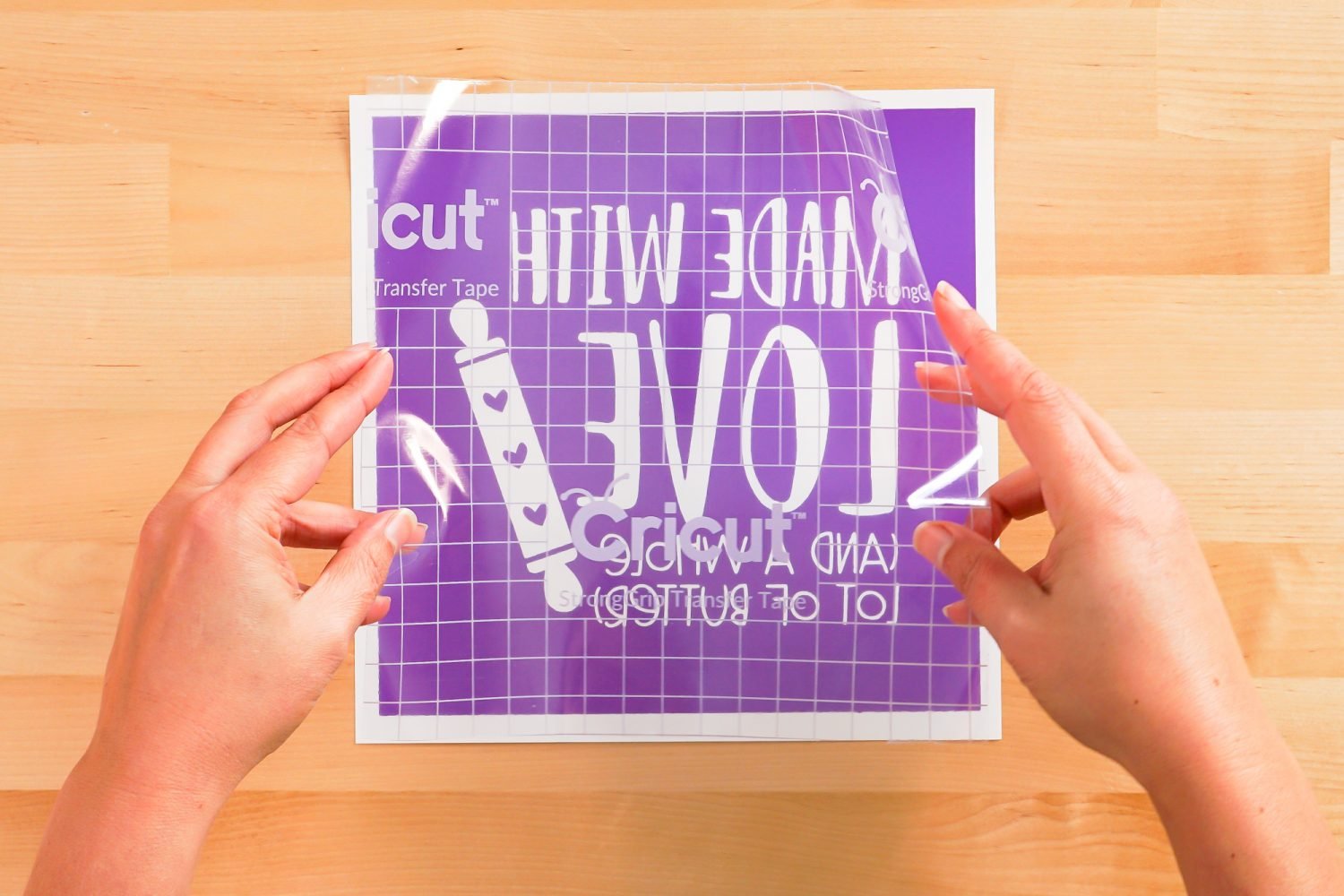 Hands placing transfer tape on image
