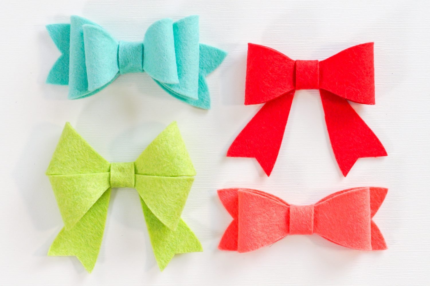 Close up picture of felt bows in aqua, red and green colors