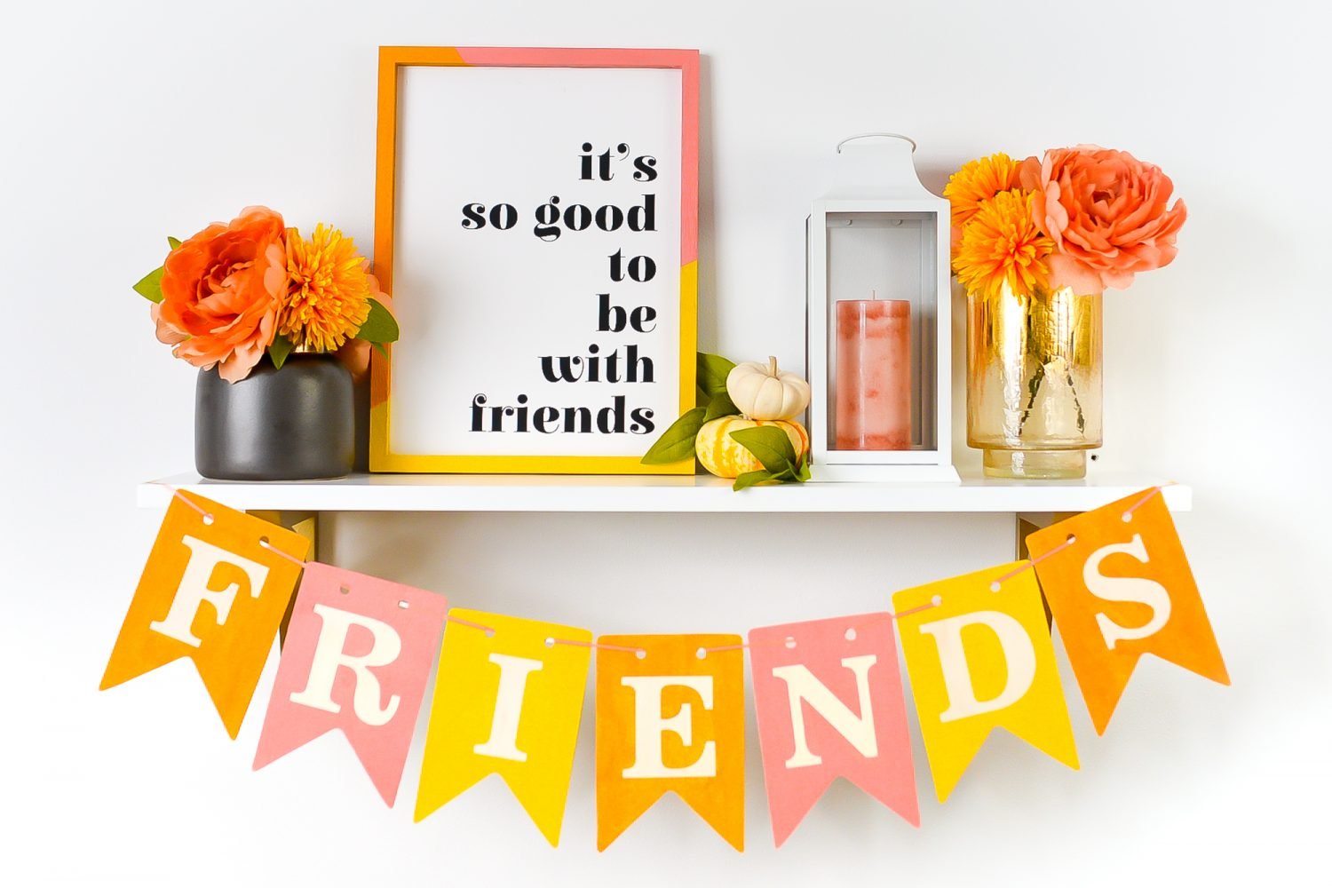 Friendsgiving decorations: friends sign, friends banner, faux flowers, candle in lantern, pumpkins