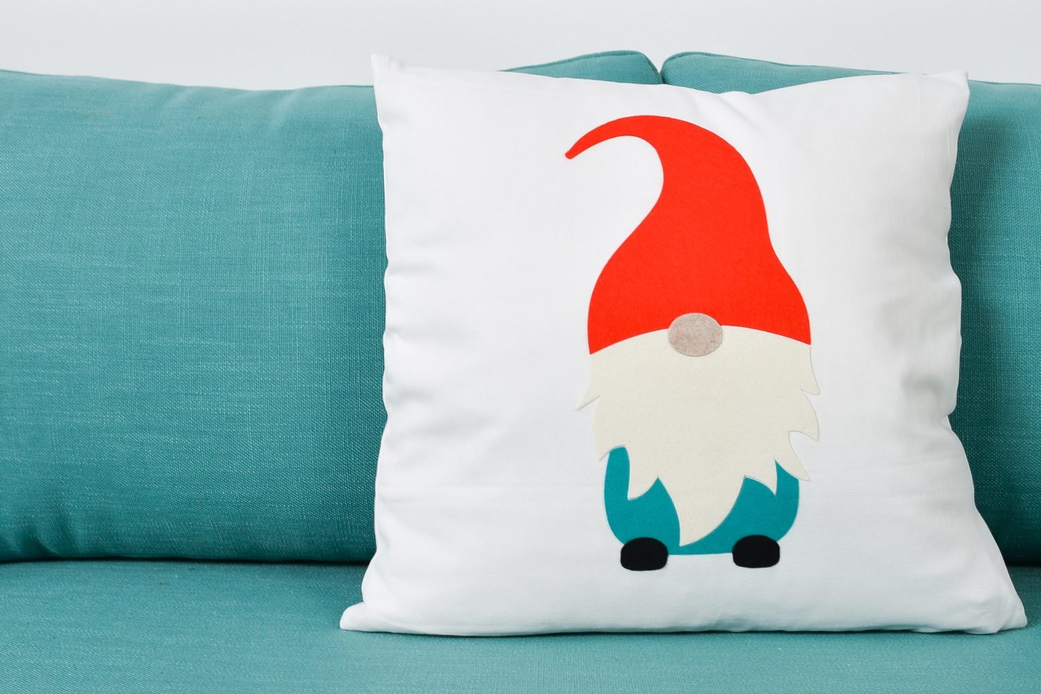 Finished gnome pillow sitting on a blue couch.