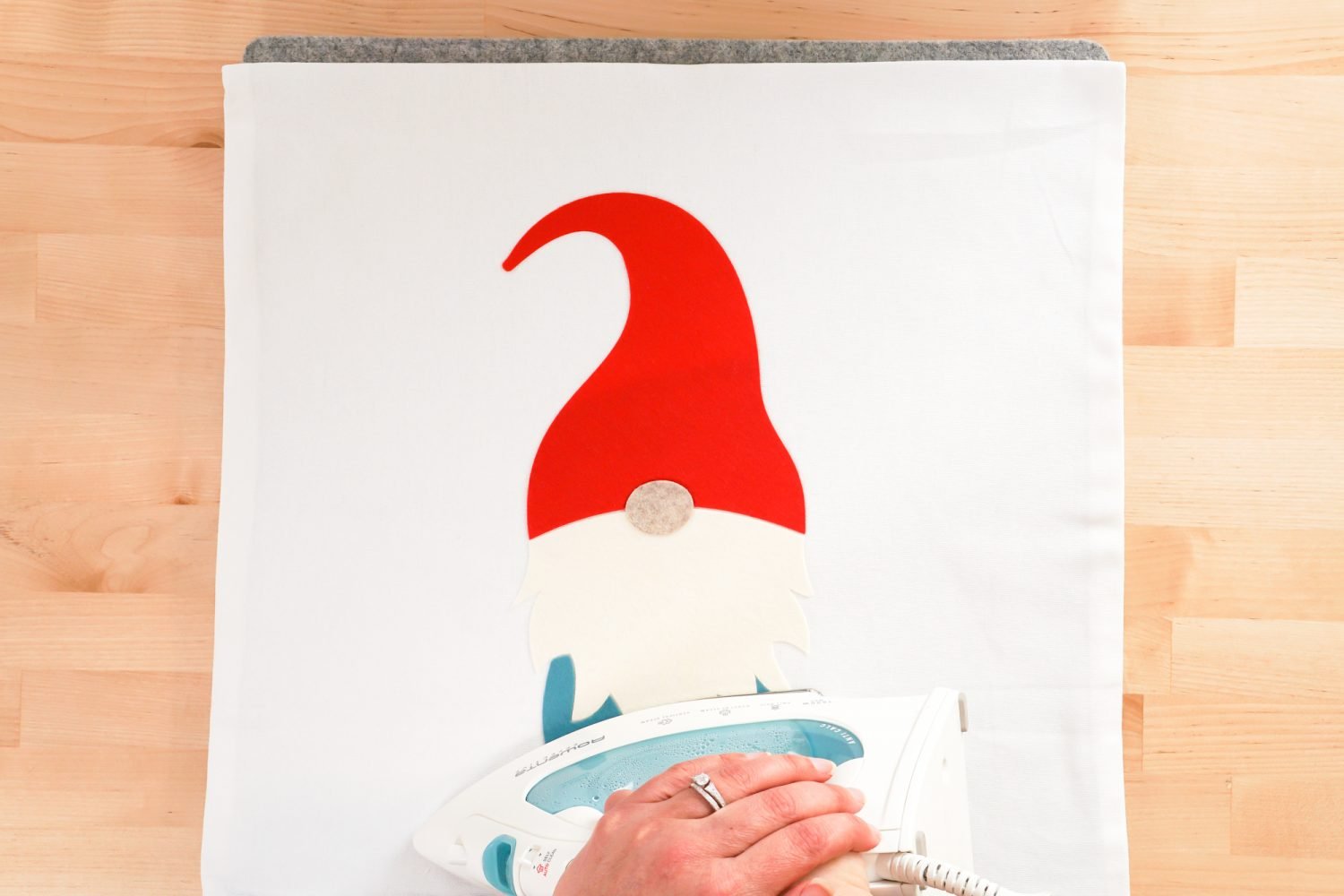 Hand pressing the gnome feet with a household iron.