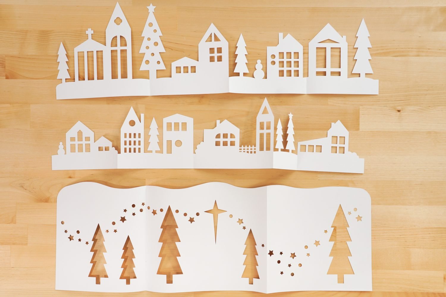 Three folded layers of the papercut Christmas village