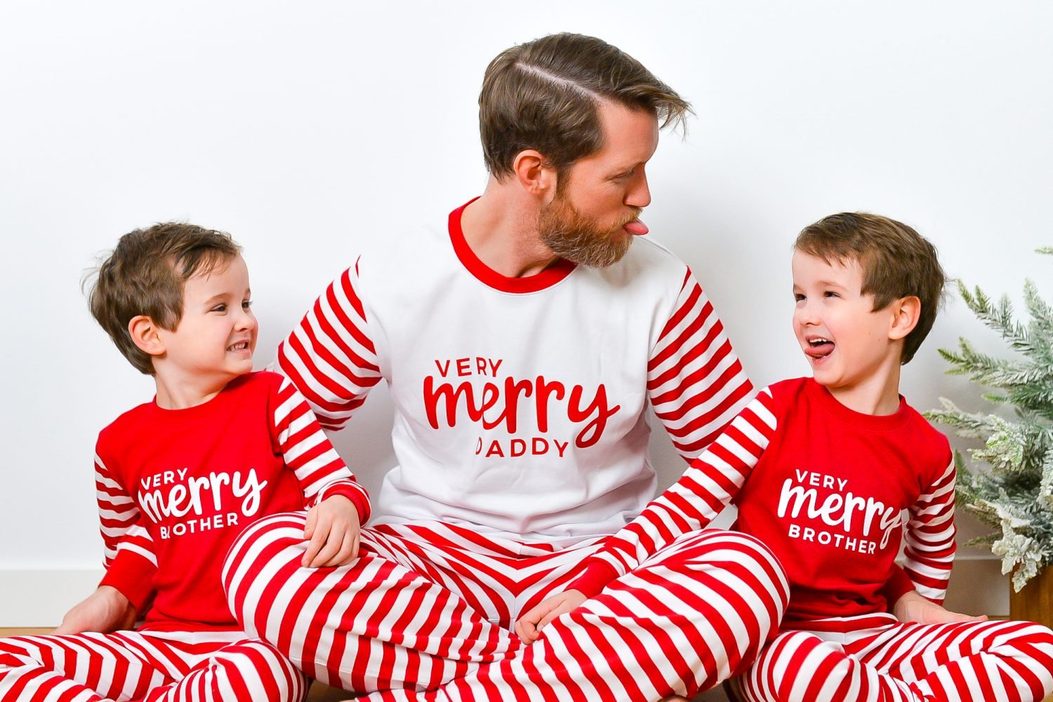 Boys wearing Very Merry Brother shirts and dad wearing Very Merry Daddy shirt