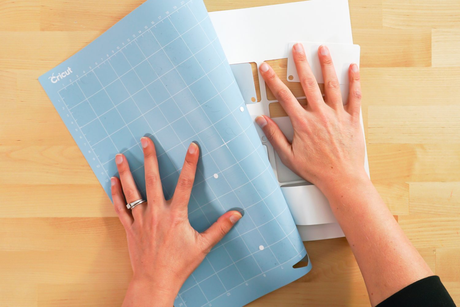 Hands showing how to remove cards from mat