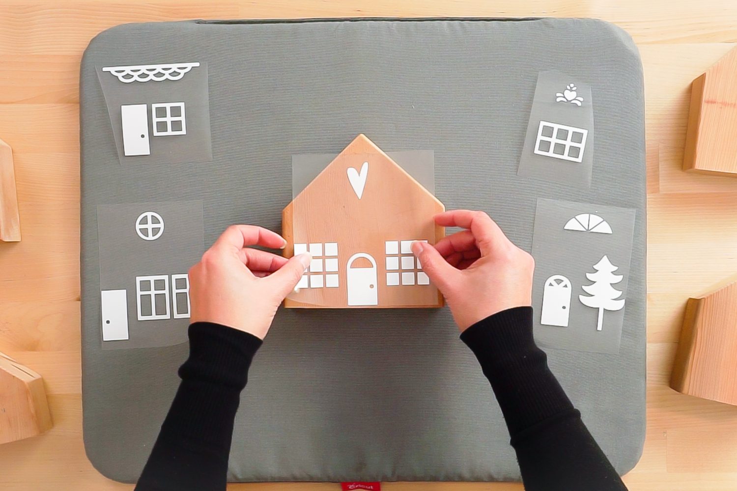 Hands placing iron on decal on wood block