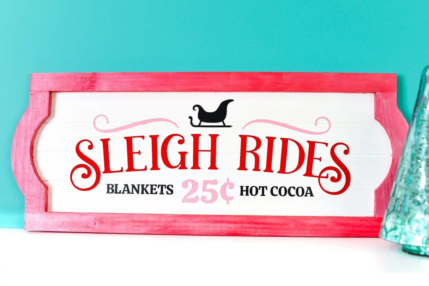 Sleigh Rides sign on white shelf with blue background and Christmas tree decor