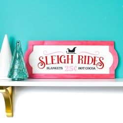 Sleigh Rides sign on white shelf with blue background and Christmas tree decor