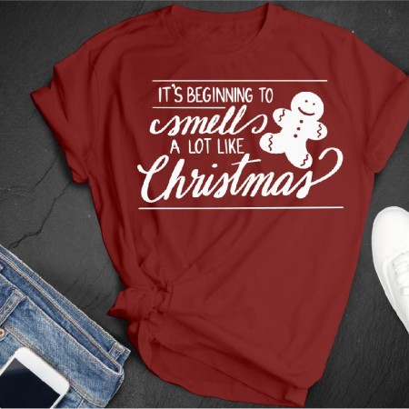 Marron colored t-shirt with an image of a gingerbread cookie on it and the saying Its Beginning to Smell a Lot Like Christmas