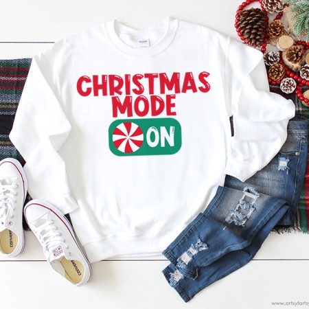 White sweatshirt that says Christmas Mode: On