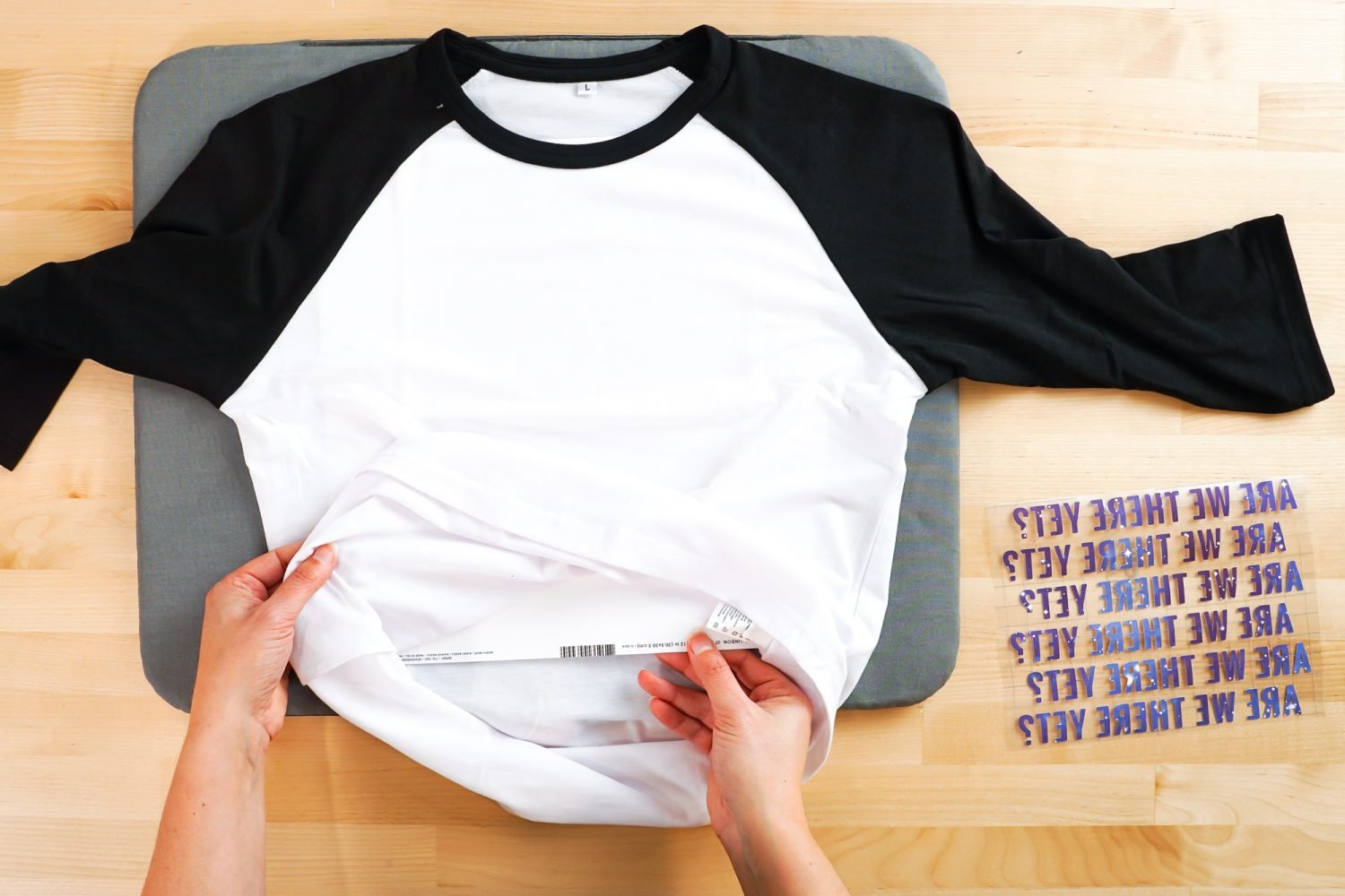 Hands putting a piece of white cardstock in the Cricut Infusible Ink raglan.