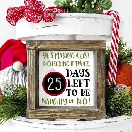 A Christmas countdown wooden framed sign with a chalkboard ornament on it and the words He's Making a List & Checking it Twice "X" Days Left to Be Naughty or Nice
