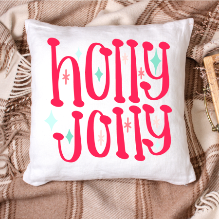 White pillow that says Holly Jolly on it