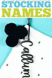 Personalized Christmas stocking with name tag created from Glowforge.  Stocking is decorated with small stars and three black pom-poms