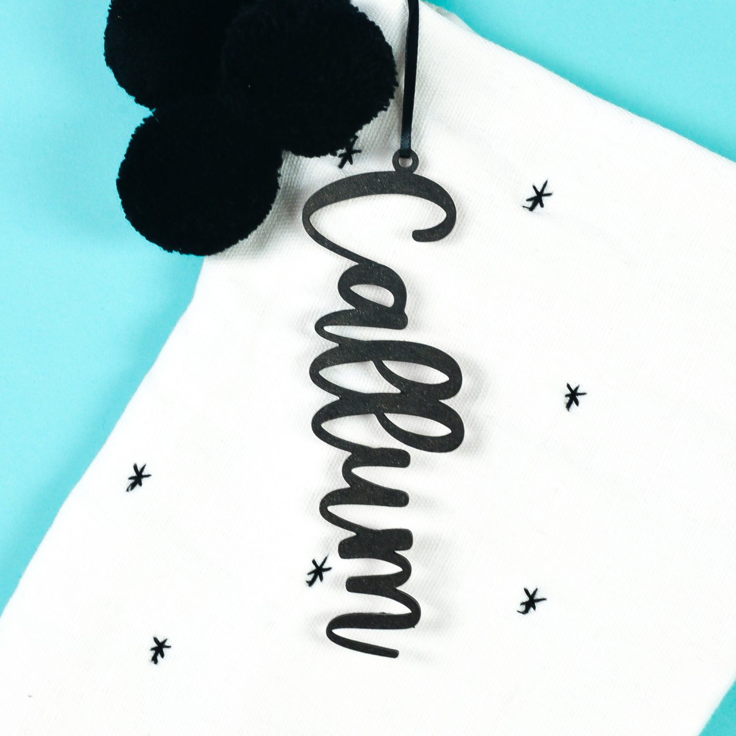 White stocking with black "Callum" tag on teal background