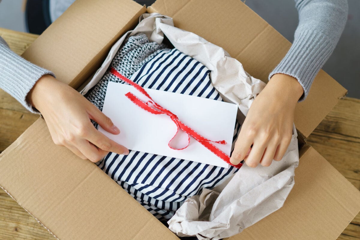 Hands packaging a gift to send in the mail