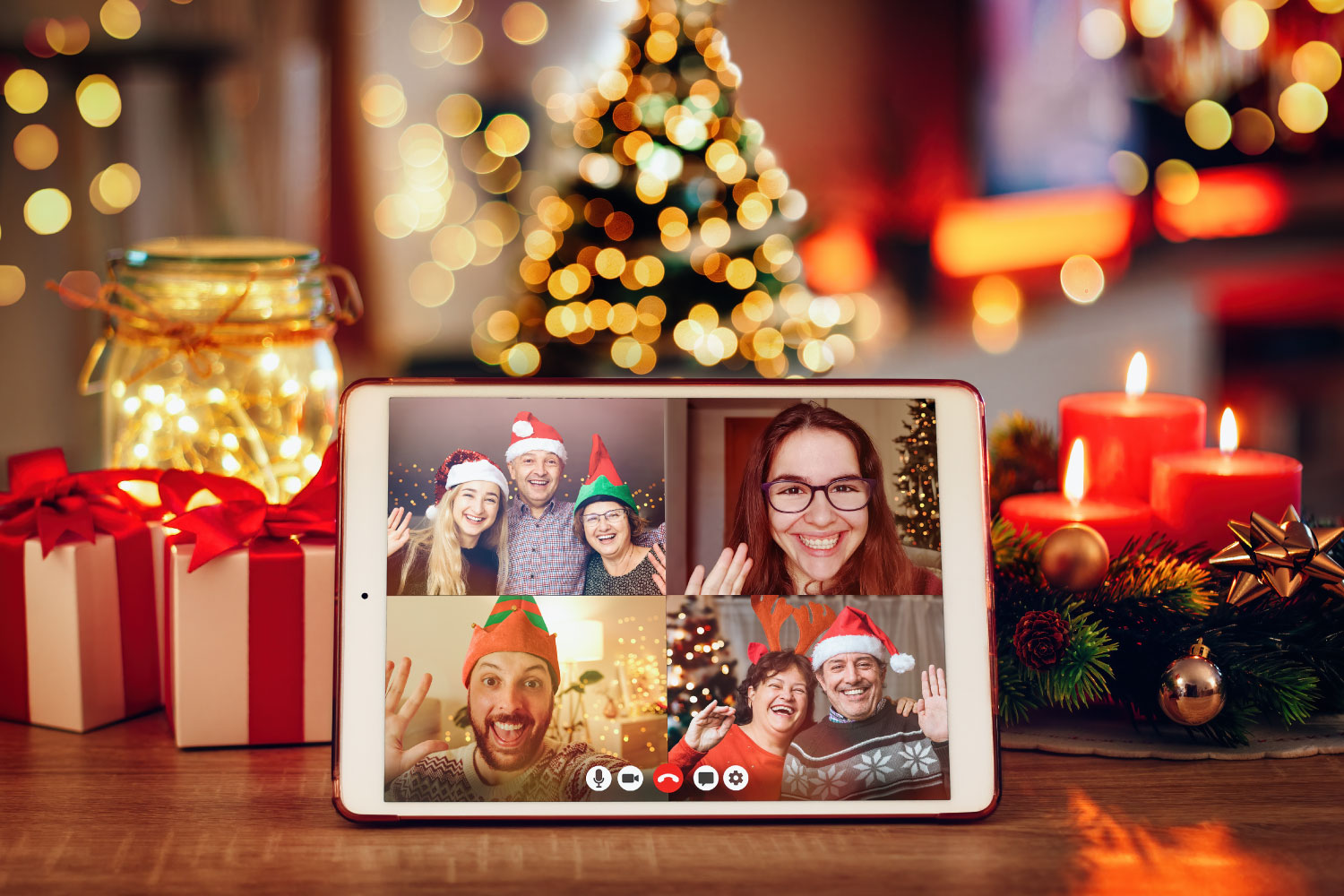Picture of iPad on table surrounded by holiday decor and displaying members attending a virtual Secret Santa Party