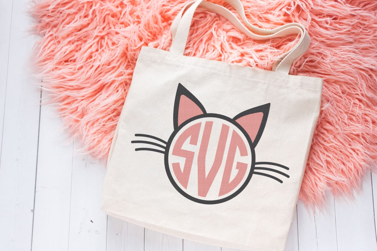 Cat Monogram SVG file on a natural tote bag which is sitting on a pink fur rug