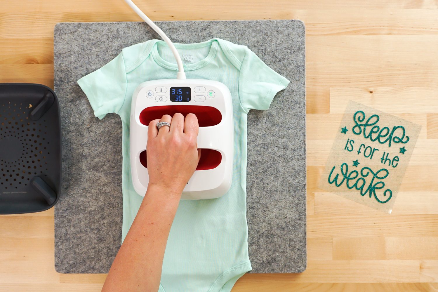 Overhead shot: hand using EasyPress to pre-heat onesie