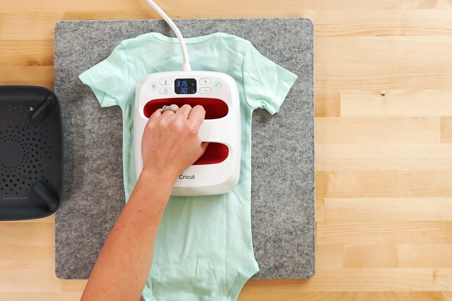 Overhead shot: hand pressing the back of the onesie with the EasyPress