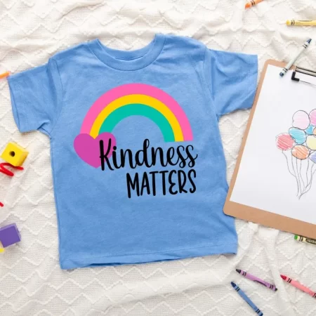 Blue t-shirt with image of a rainbow and heart with the words Kindness Matters