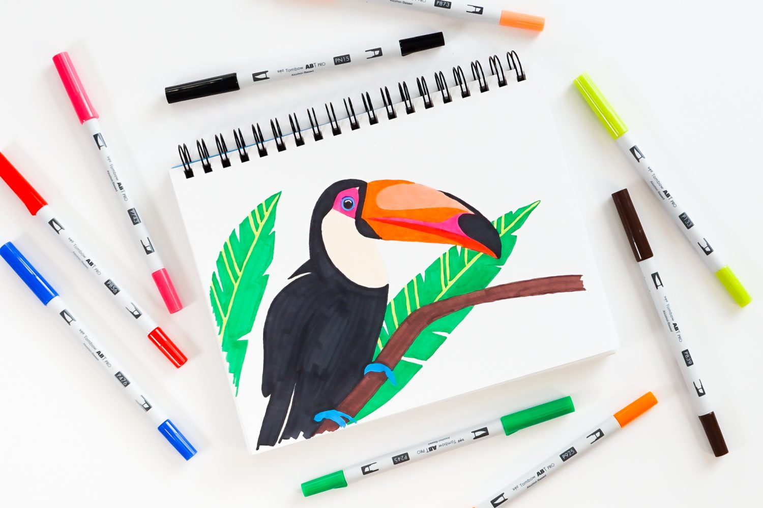 Toucan illustration with Tombow ABT PRO Markers surrounding the drawing