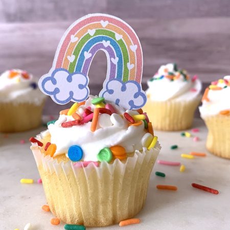 Cupcake with a rainbow cake topper on it