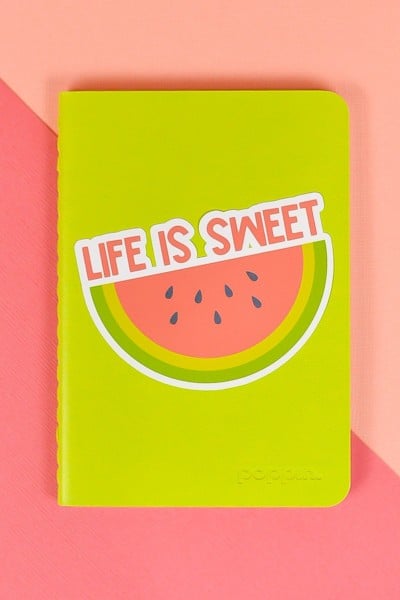 Life is Sweet watermelon sticker on green notebook on pink background