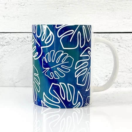 A coffee mug with a Monstera leaves design on it