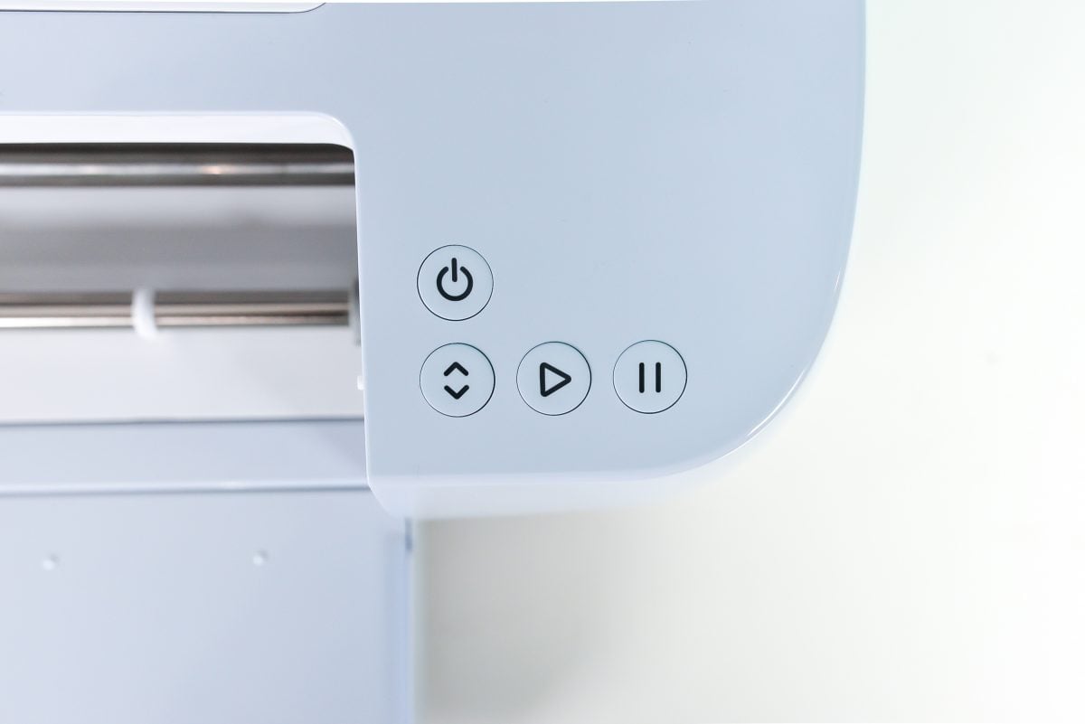 Top-down view of Cricut Maker 3's buttons: power, insert, play, pause.