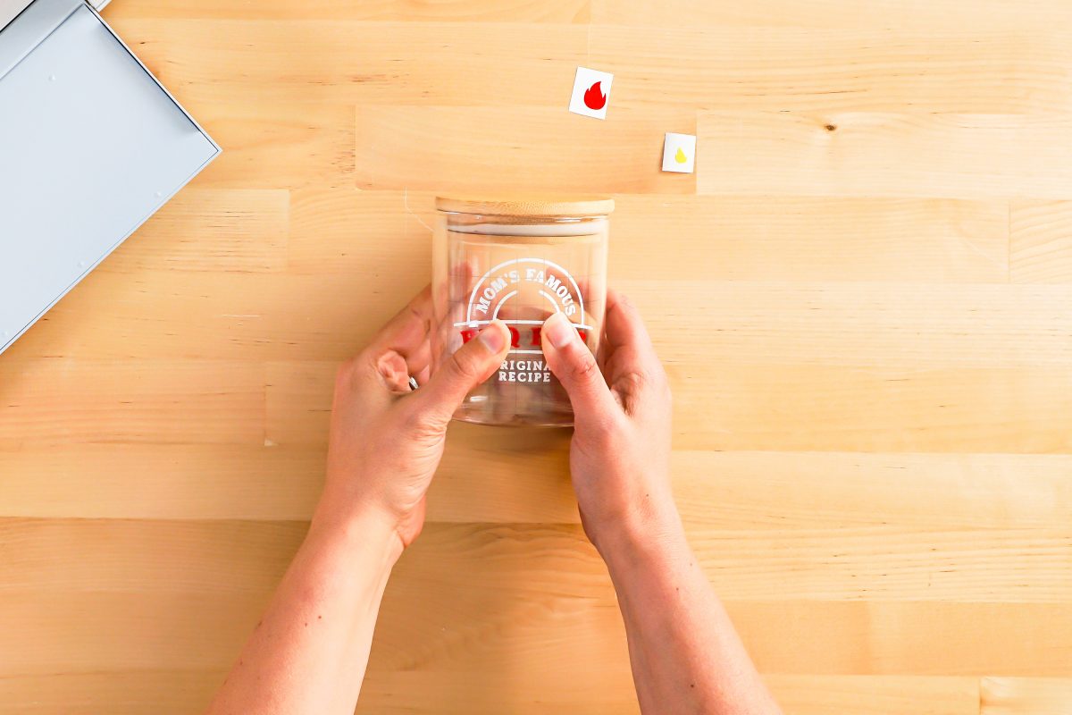 Hands burnishing label to the jar