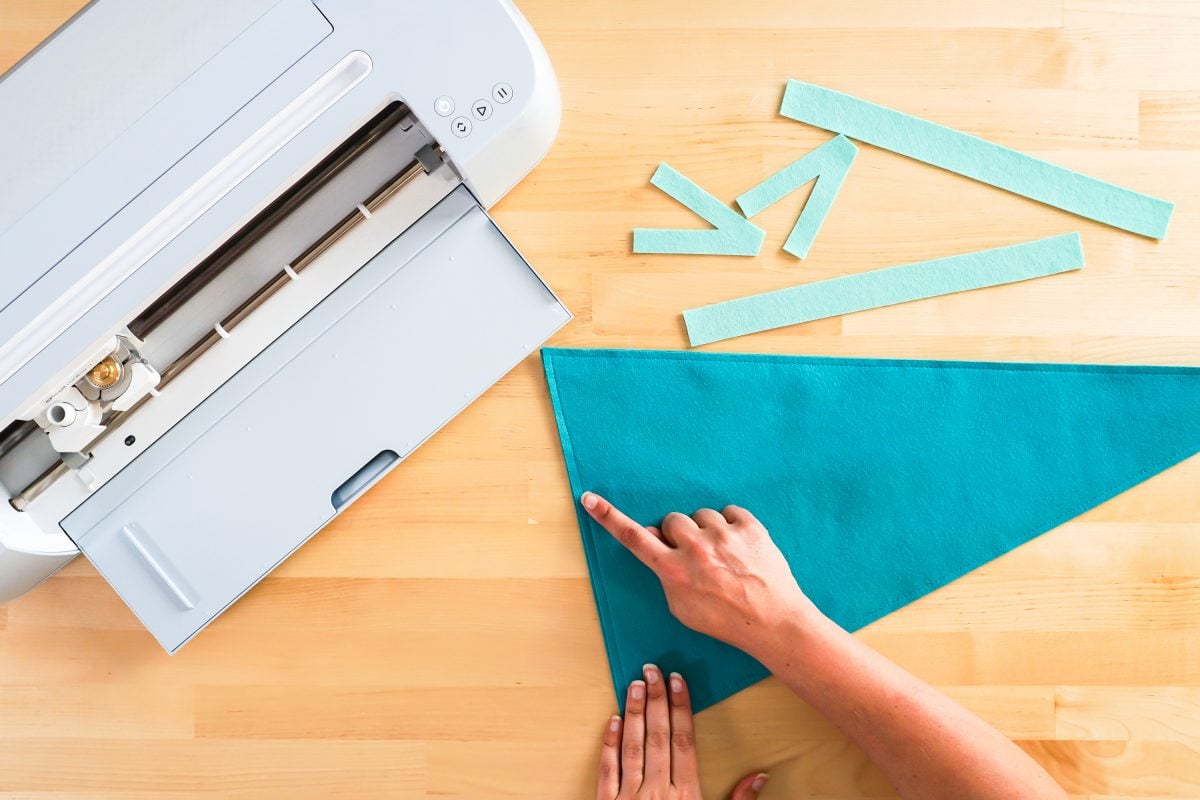 Hands showing where to sew around edge of pennant