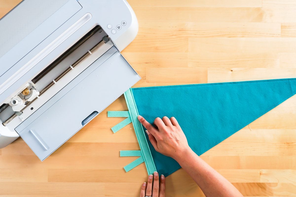 Hands showing where to sew for pennant binding and flags