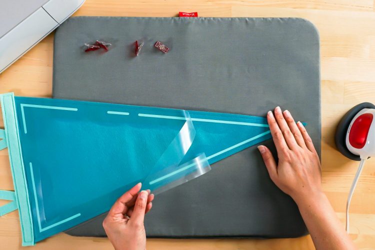 Hand peeling back iron on carrier sheet