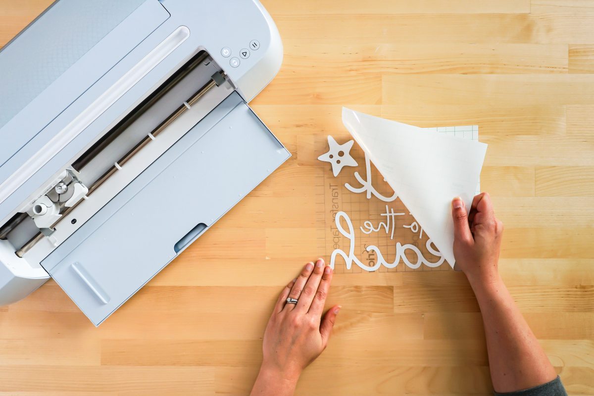 Hands peeling back carrier sheet on vinyl