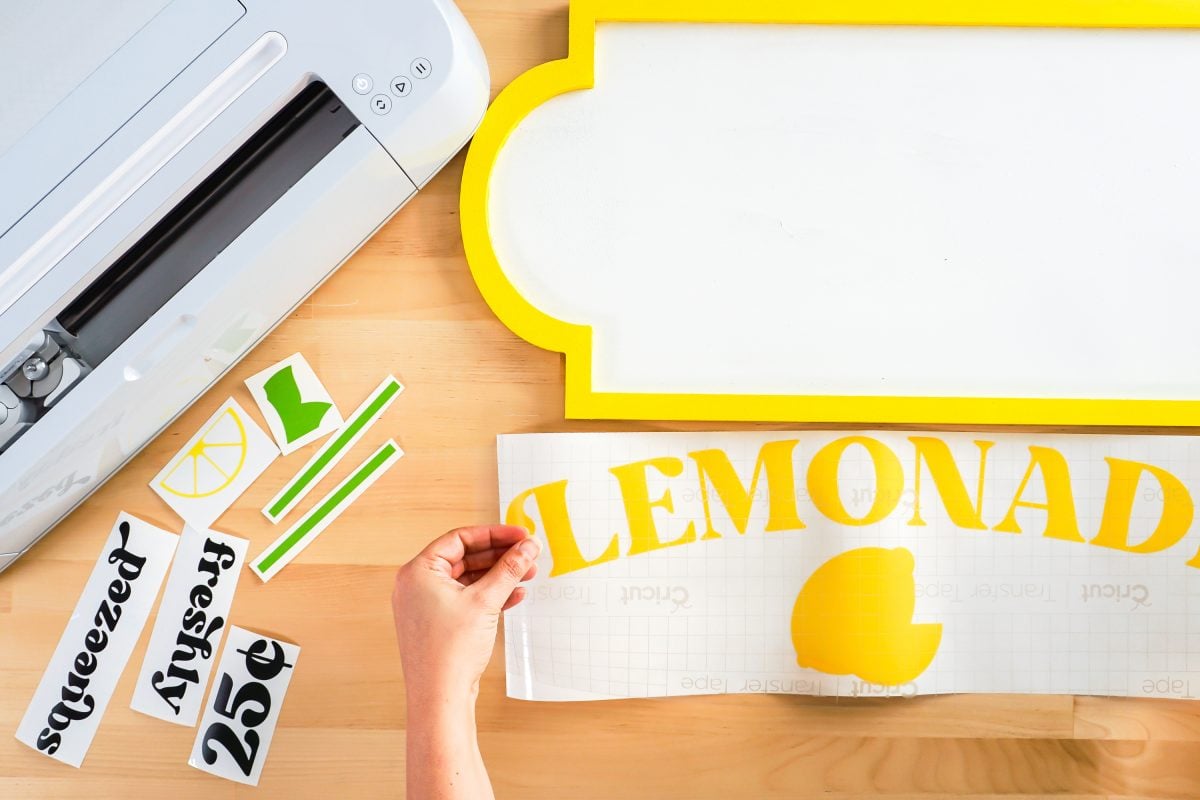 Hands applying transfer tape to large lemonade decal.