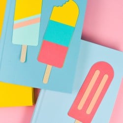 Final popsicle bookmarks styled with bright books on a pink background