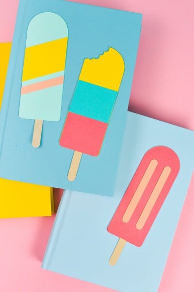 Final popsicle bookmarks styled with bright books on a pink background