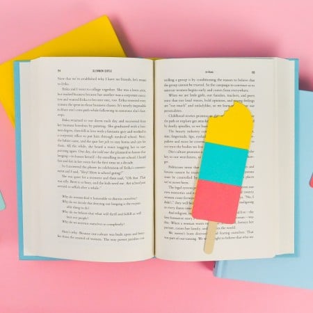 Final popsicle bookmarks styled with bright books on a pink background