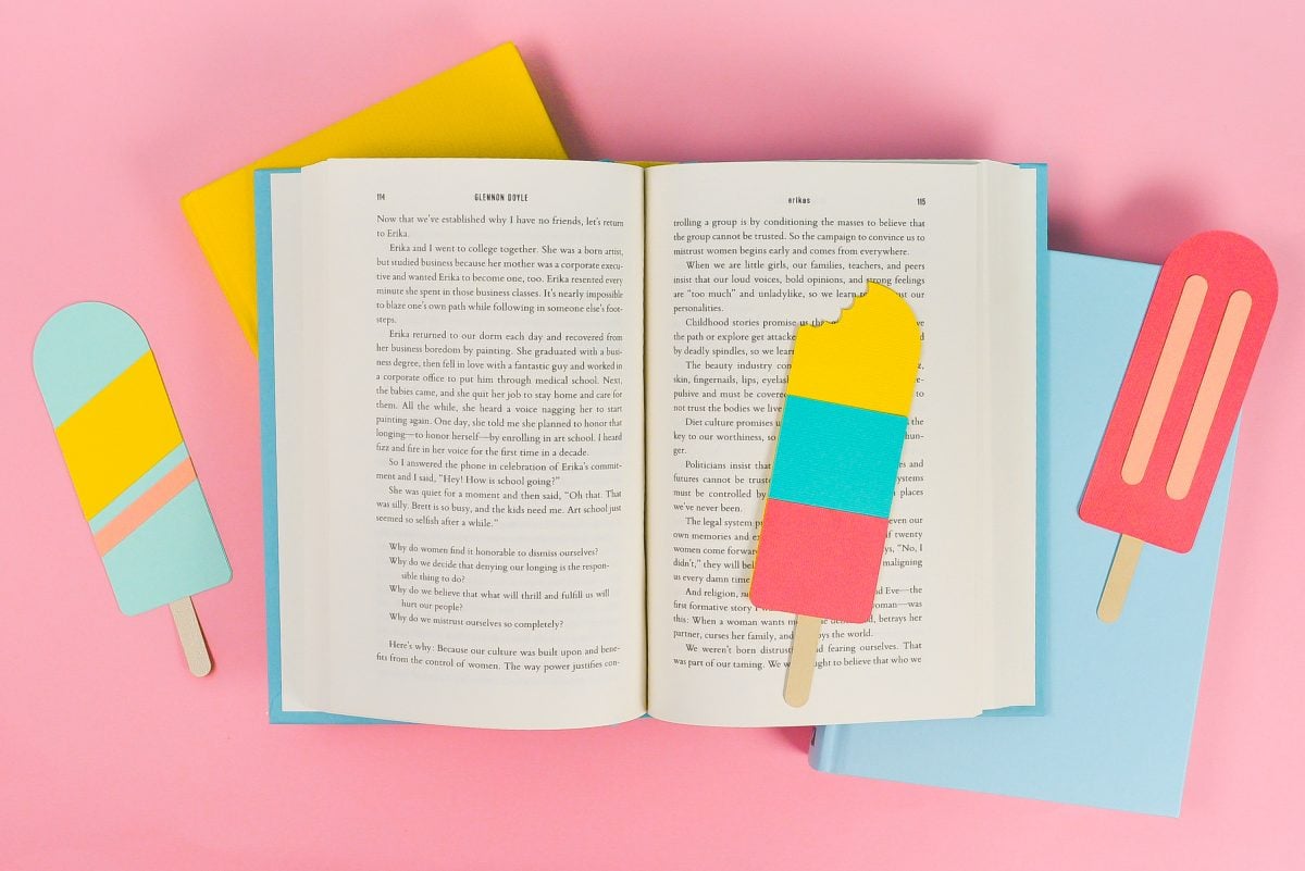 Final popsicle bookmarks styled with bright books on a pink background