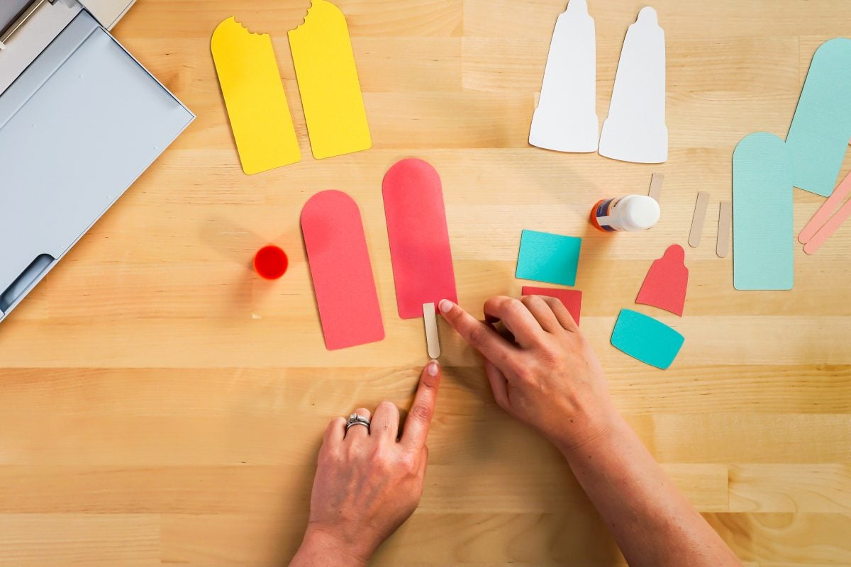 Hands assembling popsicle bookmarks