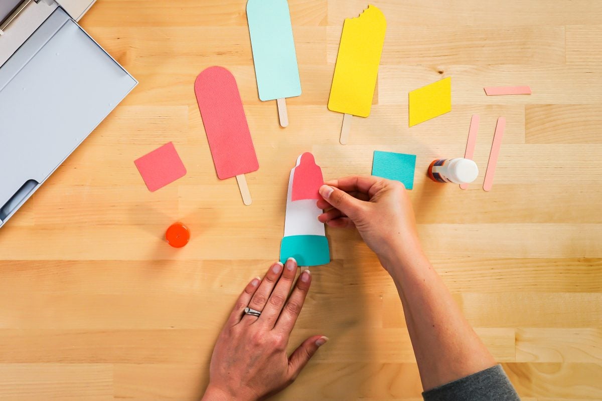 Hands assembling popsicle bookmarks