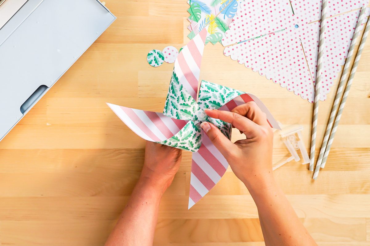 Hands adding end cap to pinwheel accessory.