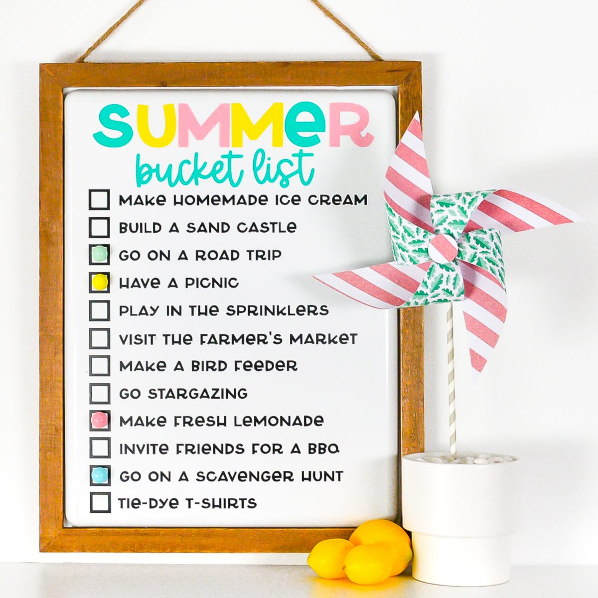 Finished summer bucket list board staged with lemons and a pinwheel.