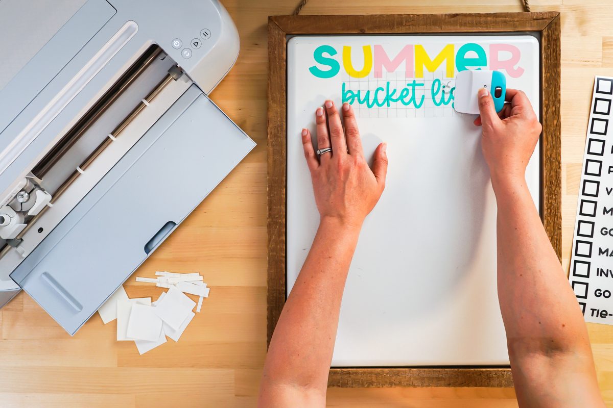 Hands burnishing the words "bucket list" to the white board.