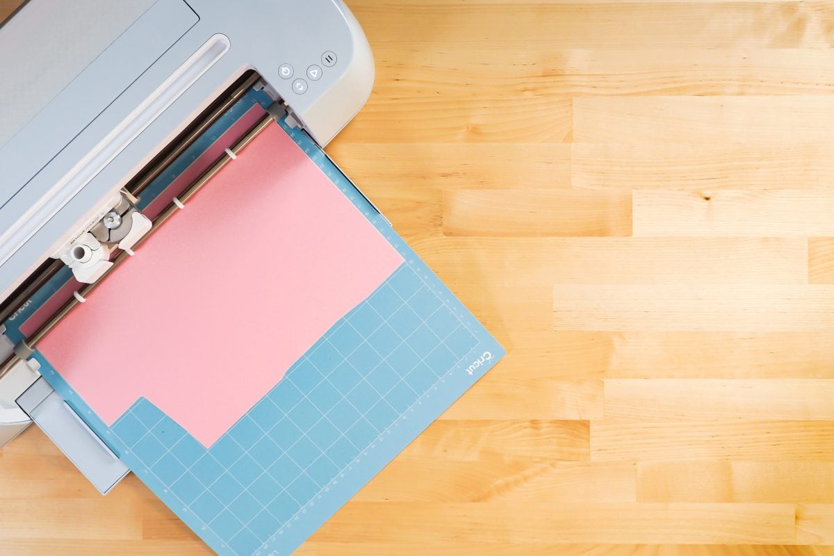 Cricut Maker 3 cutting pink vinyl on mat.