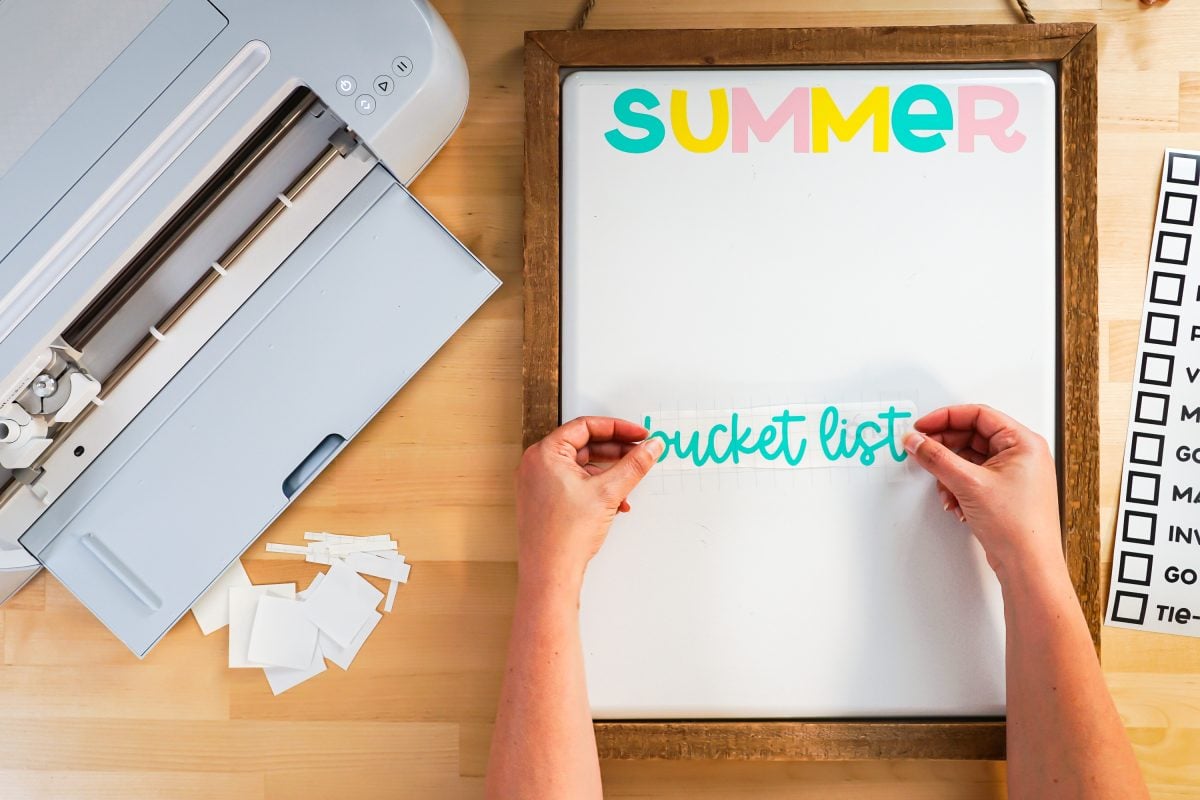 Hands adding transfer tape to words "bucket list."