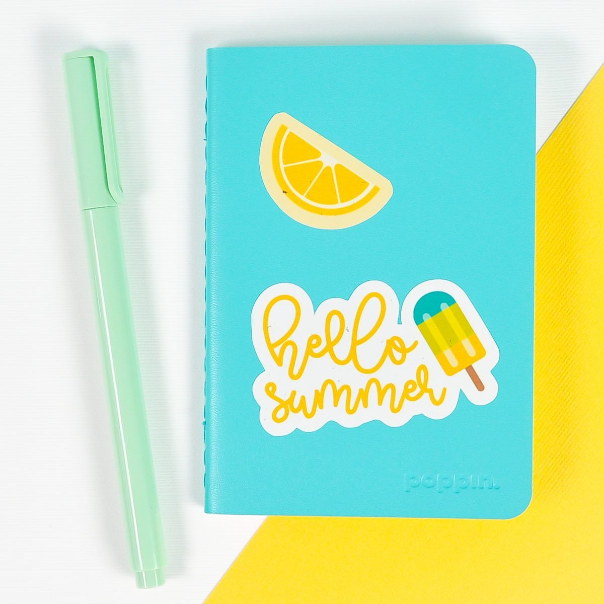 Blue notebook with summer stickers on white and yellow background
