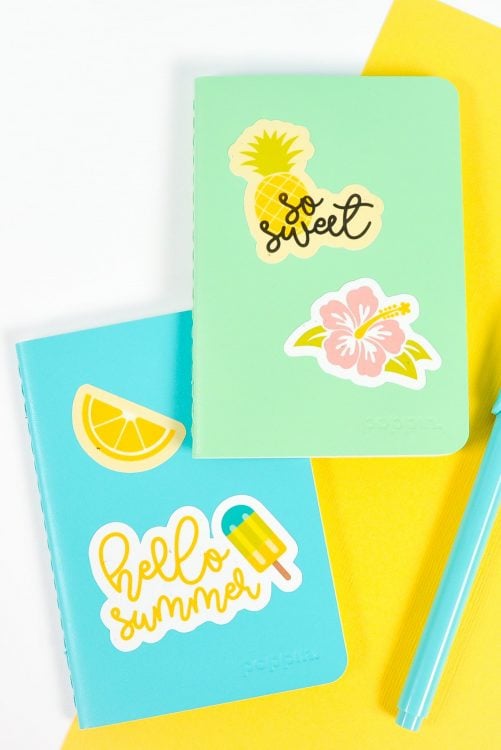 Blue and green notebooks with summer stickers on white and yellow background
